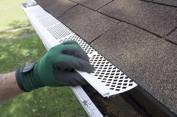 gutter guards act as a barrier, blocking leaves and other debris from entering the gutter